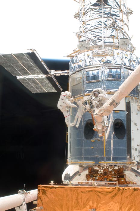 La nave espacial revestida de metal se ve de cerca.  Los astronautas lo sirven.