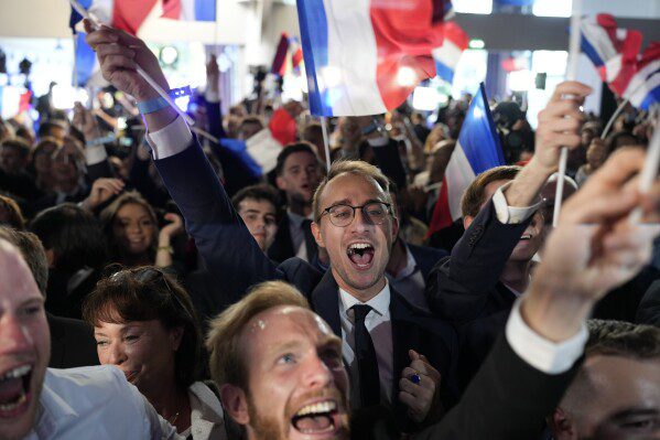 Los partidarios de la Agrupación Nacional de extrema derecha de Francia reaccionan en la sede del partido la noche de las elecciones, el domingo 9 de junio de 2024, en París.  Los primeros resultados esperados en Francia sitúan al partido de extrema derecha Agrupación Nacional en una ventaja significativa en las elecciones de la Unión Europea, según los institutos electorales franceses.  (Foto AP/Louis Joly)