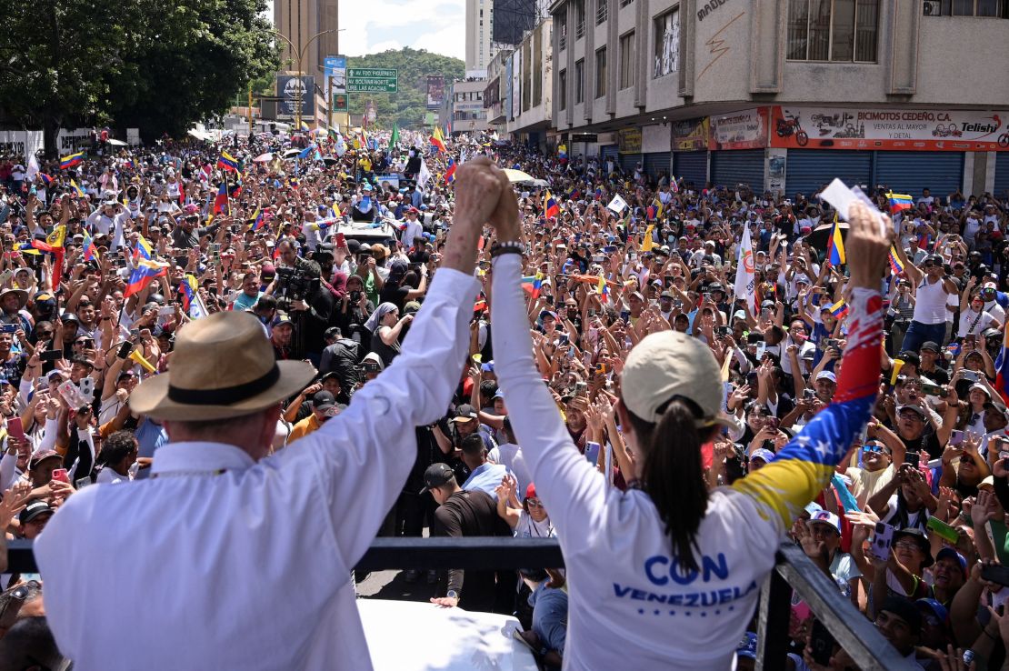 El candidato presidencial de la oposición venezolana, Edmundo González, y la líder opositora María Corina Machado se dan la mano en un mitin de campaña presidencial en Valencia, estado de Carabobo, Venezuela, el 13 de julio de 2024.