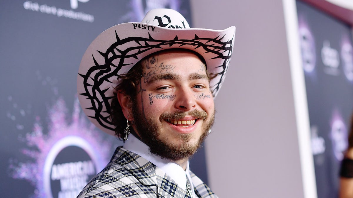 El rapero Post Malone lleva un sombrero de vaquero rosa y un traje a juego.